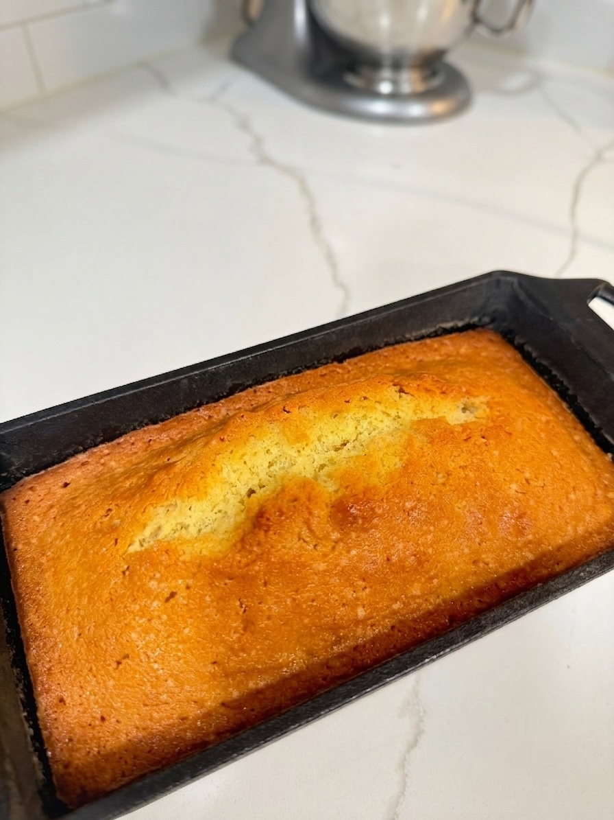 Golden quatre-quarts loaf fresh out of the oven in a cast iron pan