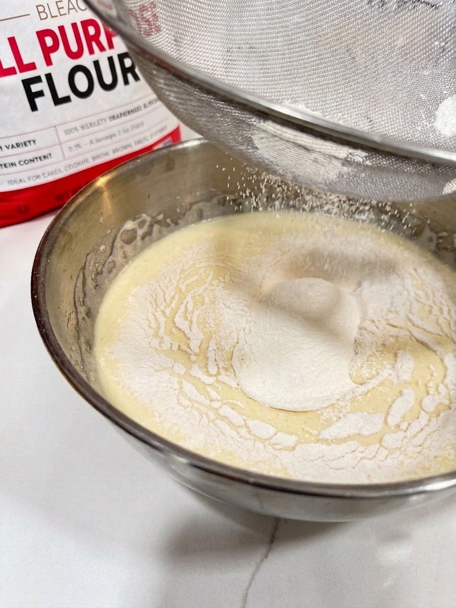 Flour being sifted into the batter